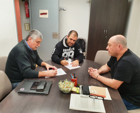 Representants de l'associació i l'alcalde de Vacarisses, signant el conveni.